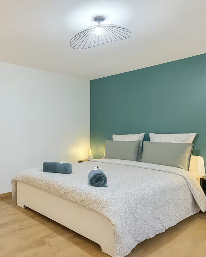 Chambre préparée par Régis, serviettes roulées sur le lit